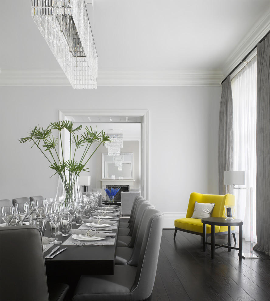 Contemporary dining room in London with grey walls and dark hardwood floors.