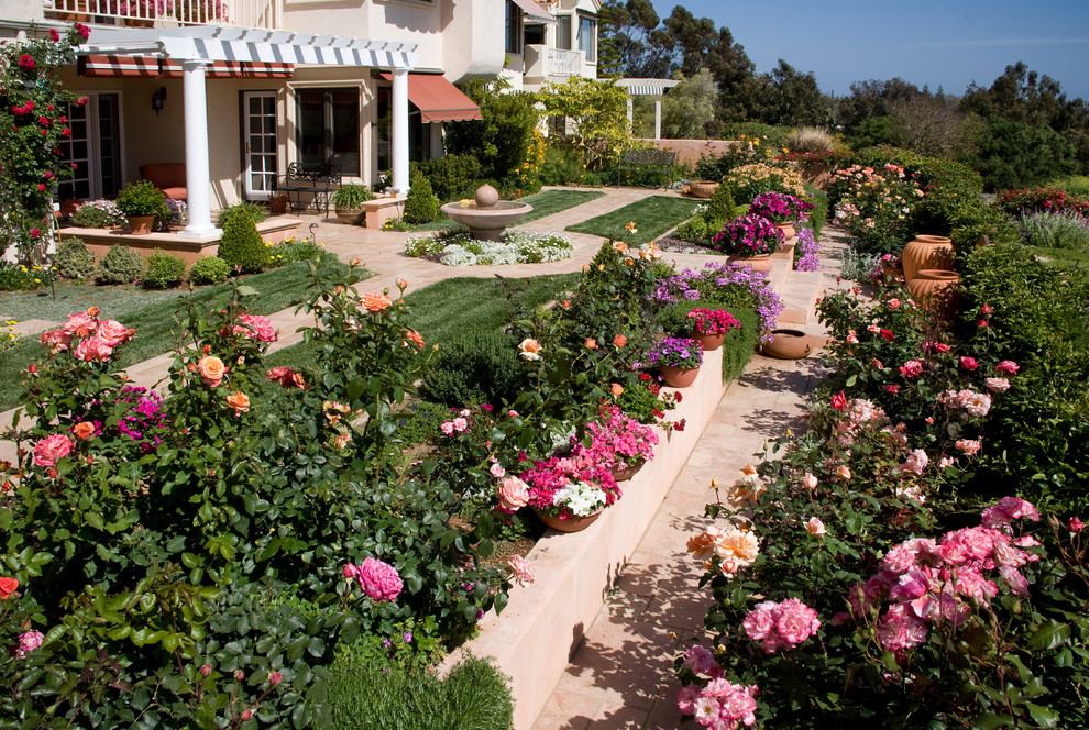 Mid-sized traditional backyard full sun formal garden in Santa Barbara with a retaining wall and decking.