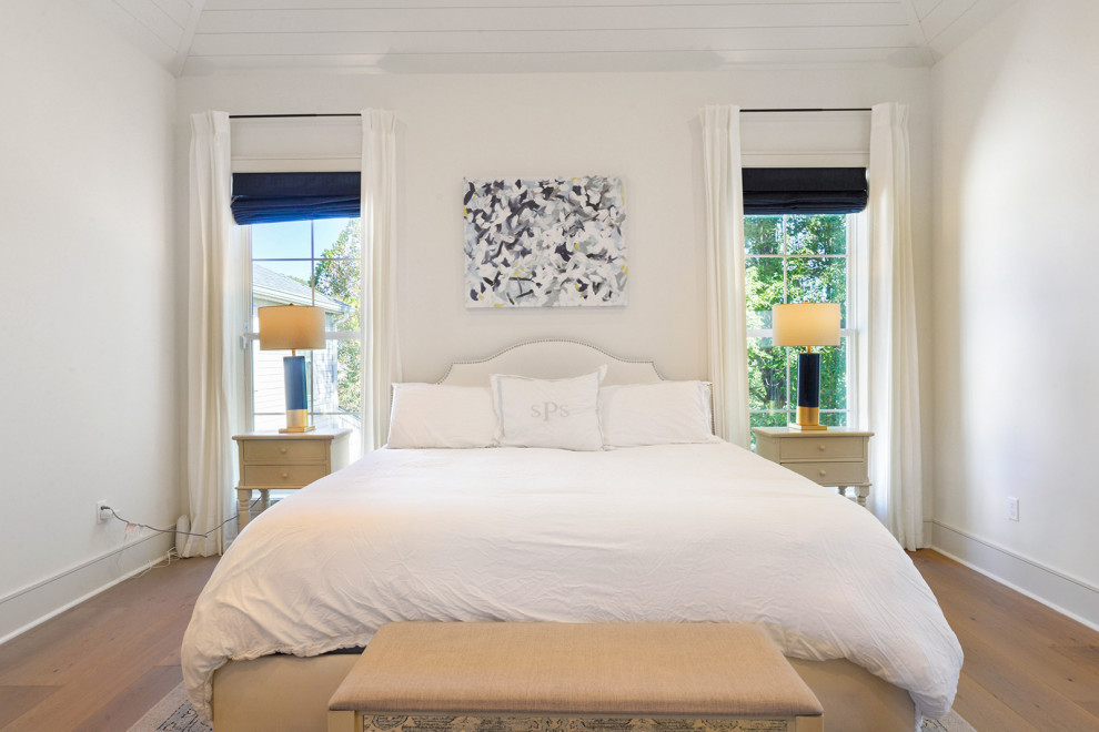 Imagen de dormitorio principal, blanco y blanco y madera de tamaño medio con paredes blancas, suelo de madera clara, suelo marrón y bandeja
