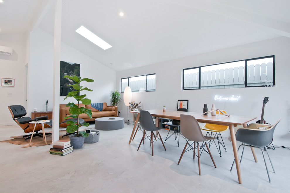Small trendy concrete floor and gray floor great room photo in Los Angeles with white walls and no fireplace