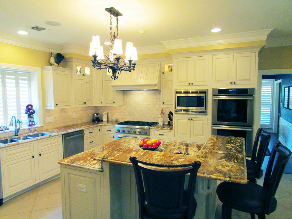 Large transitional u-shaped slate floor eat-in kitchen photo in New Orleans with an undermount sink, shaker cabinets, white cabinets, granite countertops, beige backsplash, ceramic backsplash, stainless steel appliances and an island