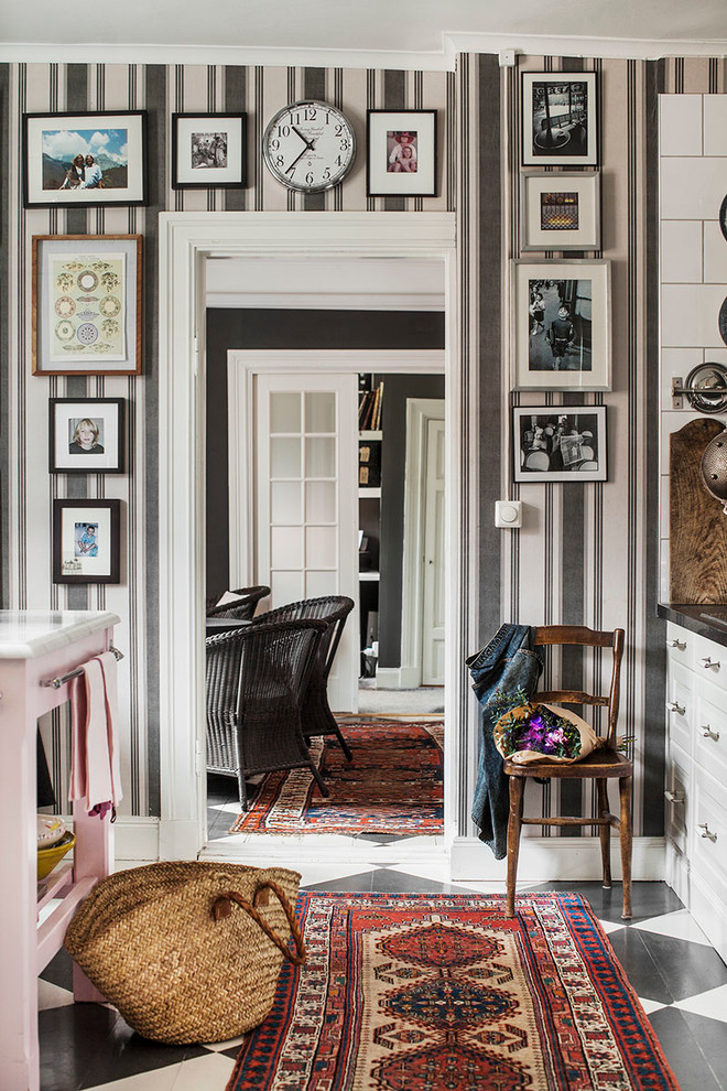 This is an example of a mid-sized eclectic hallway in Stockholm with multi-coloured walls and painted wood floors.