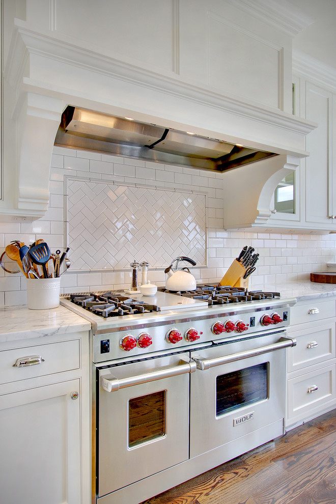Inspiration for a traditional kitchen in Seattle with glass-front cabinets, subway tile splashback and stainless steel appliances.