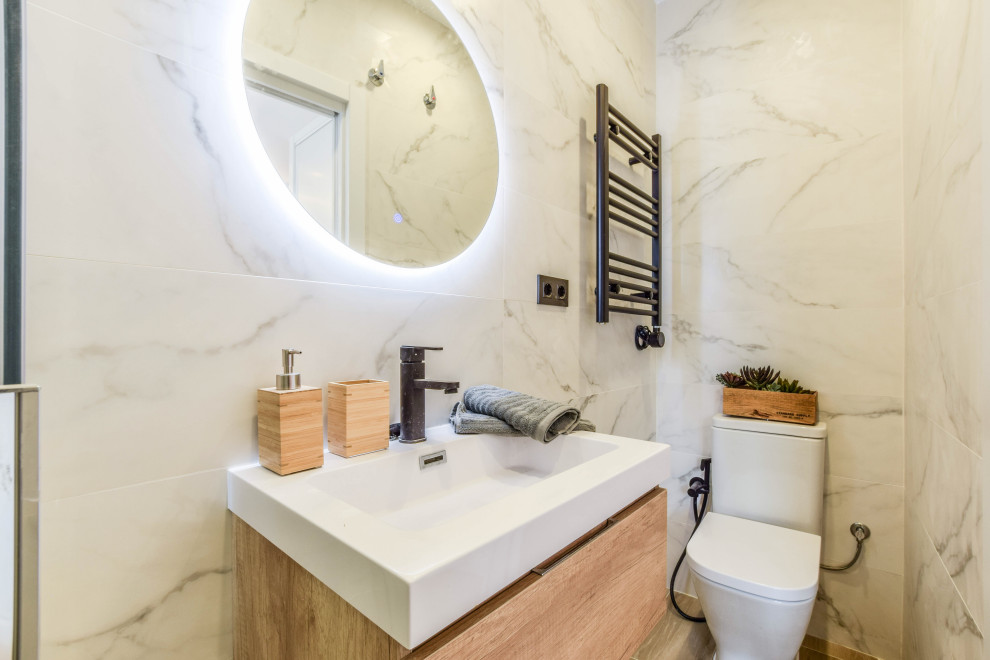 Exempel på ett litet modernt brun brunt badrum med dusch, med släta luckor, vita skåp, en kantlös dusch, en vägghängd toalettstol, svart och vit kakel, vita väggar, klinkergolv i porslin, ett integrerad handfat, träbänkskiva, brunt golv och dusch med skjutdörr