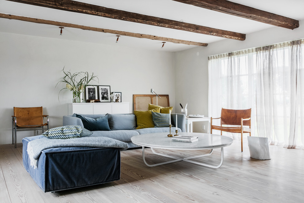 This is an example of an eclectic living room in Stockholm with white walls, light hardwood floors and beige floor.