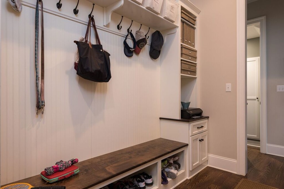 Mid-sized traditional mudroom in Other with black walls, dark hardwood floors and brown floor.