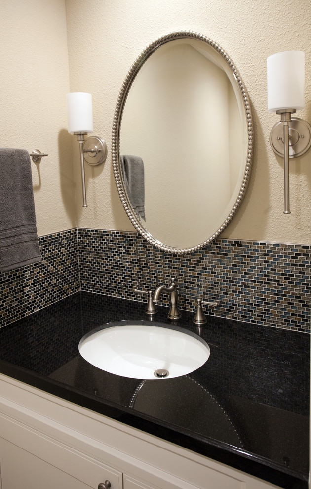 Photo of a small transitional powder room in San Francisco with shaker cabinets, white cabinets, a two-piece toilet, multi-coloured tile, glass sheet wall, beige walls, slate floors, an undermount sink, granite benchtops and multi-coloured floor.