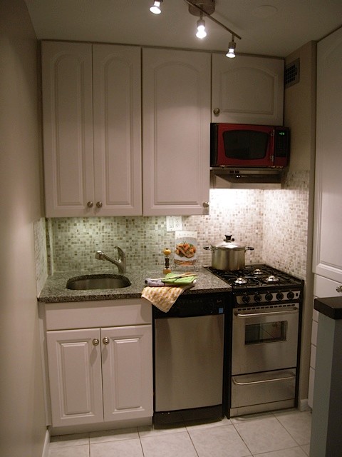 Small transitional single-wall ceramic tile enclosed kitchen photo in DC Metro with an undermount sink, raised-panel cabinets, granite countertops, multicolored backsplash, mosaic tile backsplash, stainless steel appliances and a peninsula