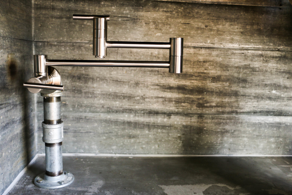 Inspiration for a slate floor kitchen remodel in Omaha with a farmhouse sink, light wood cabinets, concrete countertops, glass tile backsplash and stainless steel appliances