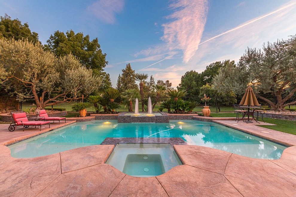 Inspiration for a large mediterranean backyard stamped concrete and custom-shaped pool fountain remodel
