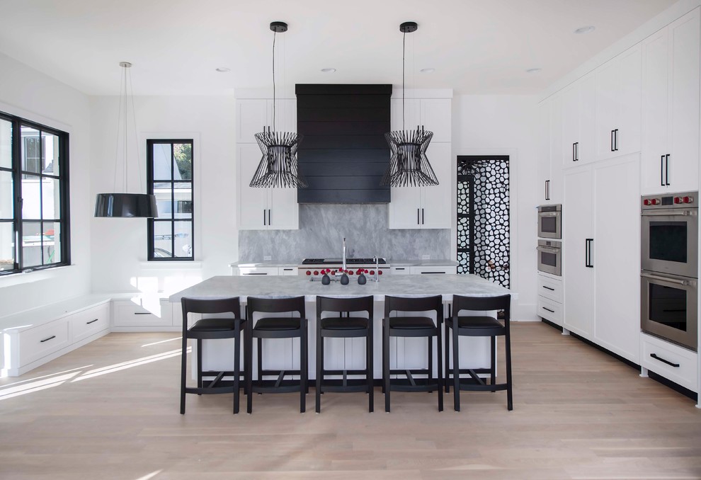 Large transitional light wood floor and beige floor kitchen photo in Atlanta with an undermount sink, shaker cabinets, white cabinets, marble countertops, gray backsplash, marble backsplash, stainless steel appliances, an island and gray countertops