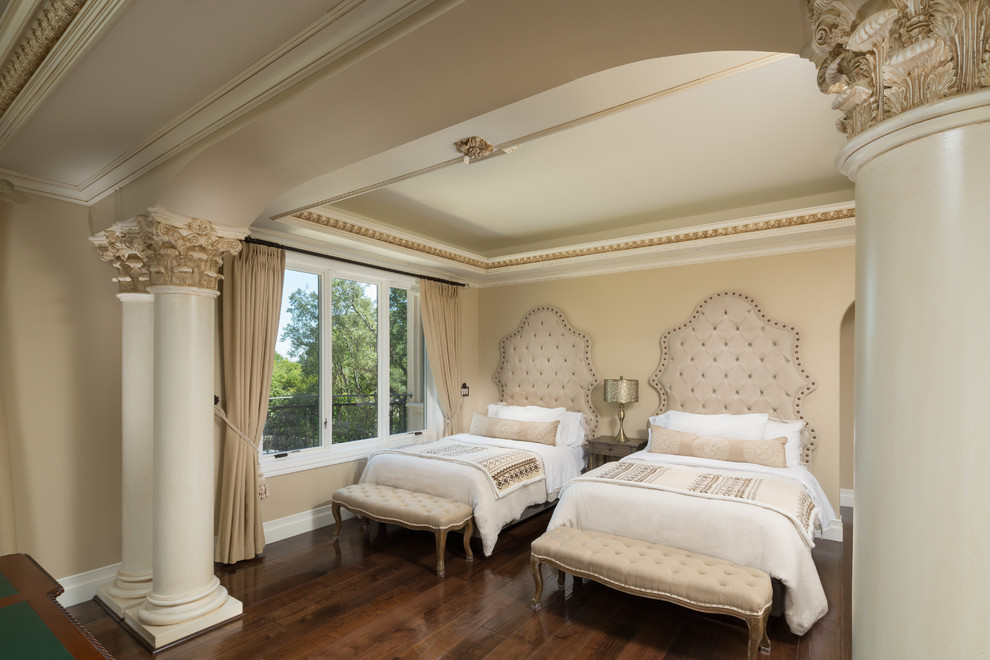 Large mediterranean guest bedroom in Los Angeles with beige walls, dark hardwood floors, a standard fireplace, a stone fireplace surround and brown floor.