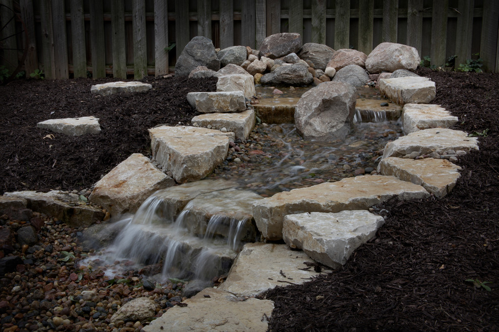 Photo of a large traditional backyard garden in Omaha with a fire feature and concrete pavers.
