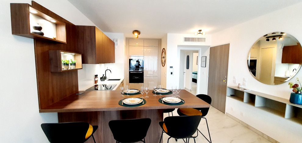 This is an example of a small contemporary u-shaped open plan kitchen in Nice with an integrated sink, flat-panel cabinets, medium wood cabinets, quartz worktops, white splashback, granite splashback, black appliances, marble flooring, a breakfast bar, white floors and white worktops.