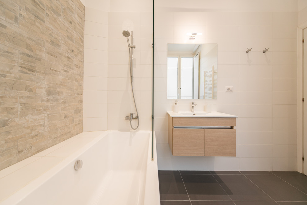 Bild på ett mellanstort minimalistiskt en-suite badrum, med släta luckor, skåp i ljust trä, ett badkar i en alkov, en dusch/badkar-kombination, ett väggmonterat handfat, svart golv och dusch med gångjärnsdörr