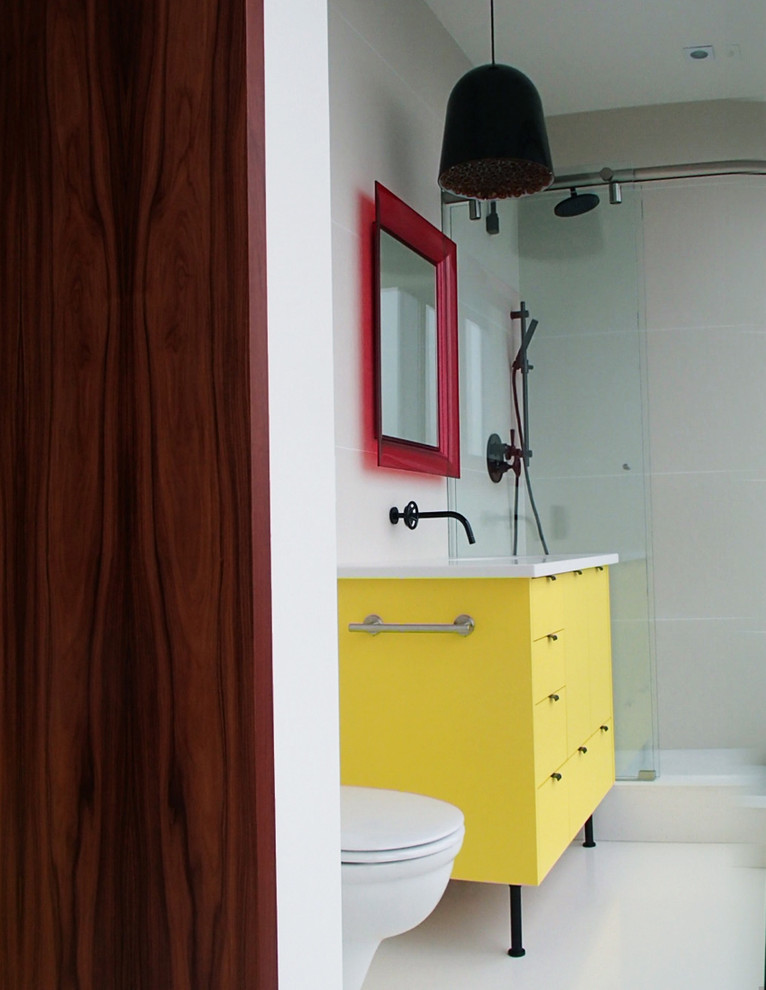 This is an example of a small modern kids bathroom in Vancouver with flat-panel cabinets, yellow cabinets, an alcove shower, a wall-mount toilet, white tile, porcelain tile, white walls, concrete floors, an undermount sink, engineered quartz benchtops, white floor and a sliding shower screen.