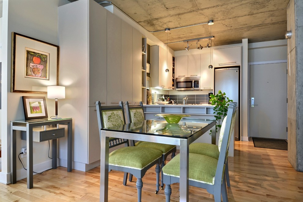 This is an example of a contemporary kitchen/dining combo in Montreal with medium hardwood floors.