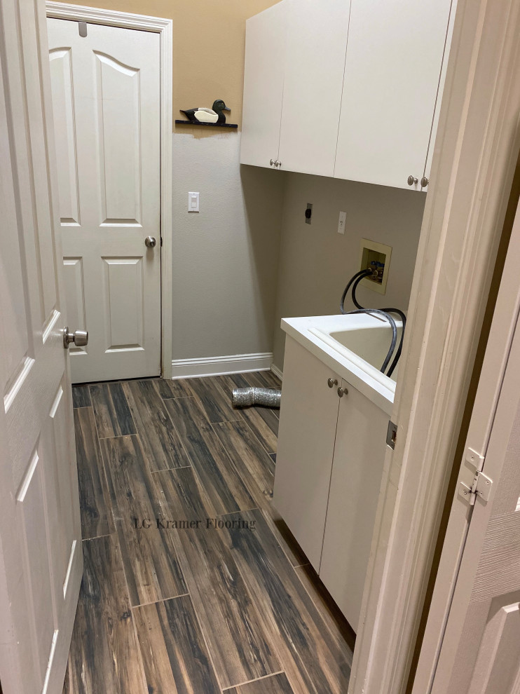 Mid-sized laundry room in Tampa with brown floor and porcelain floors.