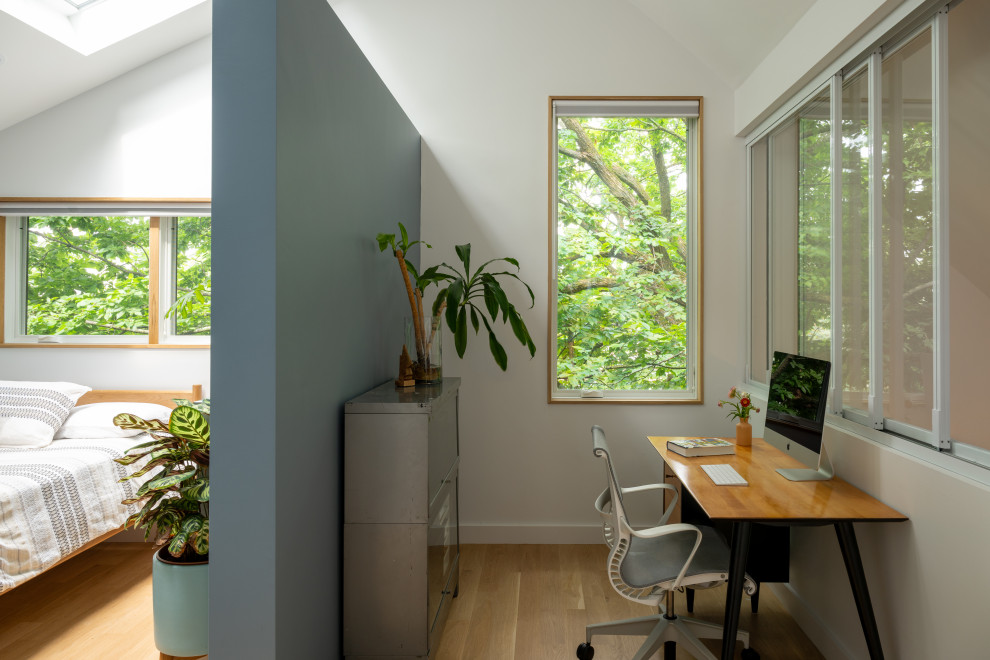 Small minimalist freestanding desk light wood floor, beige floor and vaulted ceiling study room photo in Boston with white walls