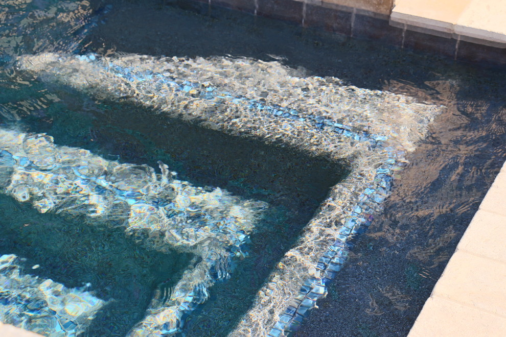 Example of a small minimalist courtyard stone and custom-shaped natural pool design in Phoenix