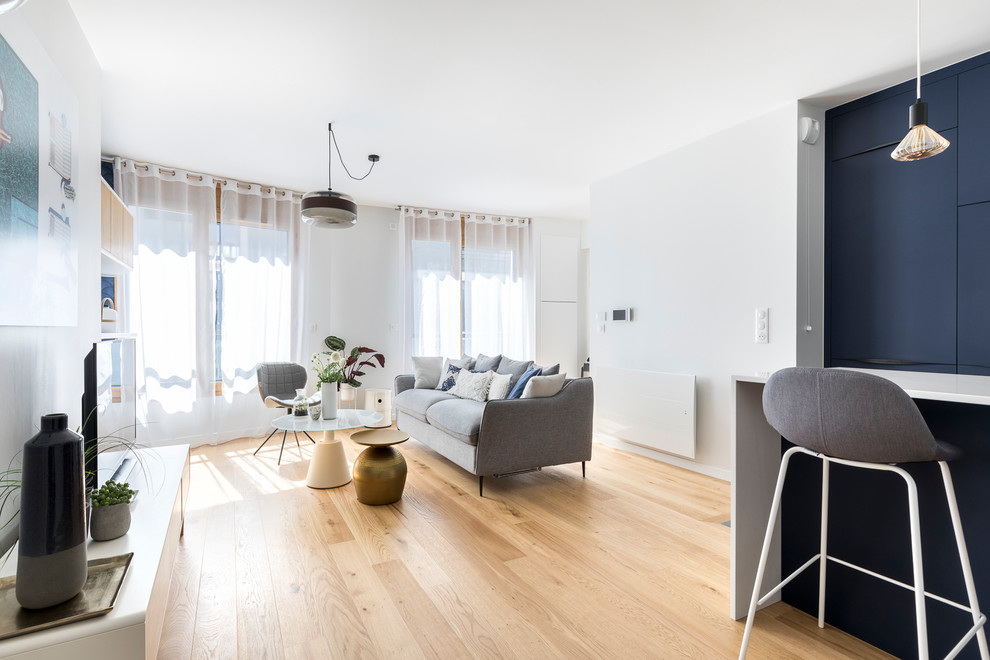Cette photo montre un petit salon bord de mer ouvert avec une salle de réception, un mur blanc, parquet clair, aucune cheminée et un téléviseur indépendant.