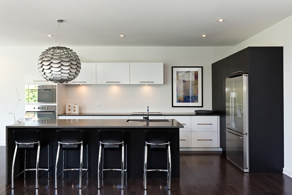 This is an example of a contemporary kitchen in Toronto with an undermount sink, flat-panel cabinets, white cabinets and stainless steel appliances.