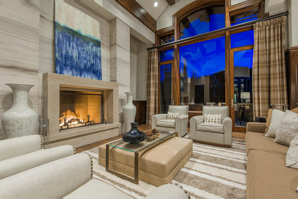 Inspiration for an expansive transitional open concept living room in Salt Lake City with grey walls, dark hardwood floors, a standard fireplace, a stone fireplace surround, a concealed tv and brown floor.