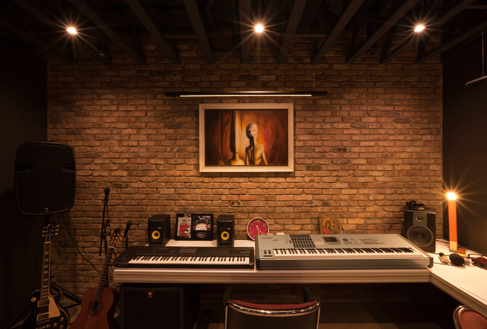This is an example of a large modern home studio in Chicago with beige walls, concrete floors, a freestanding desk and grey floor.