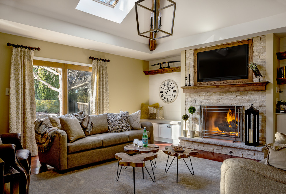 Inspiration for a mid-sized country family room in Chicago with beige walls, a standard fireplace, a stone fireplace surround and a wall-mounted tv.