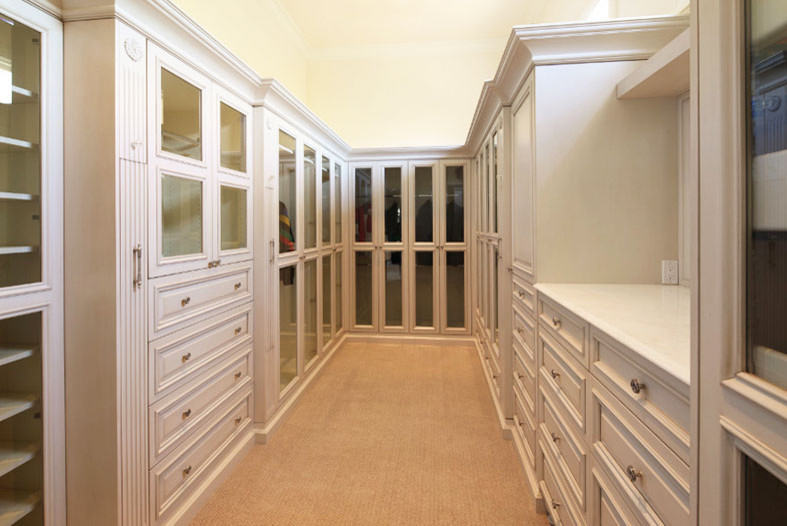 Inspiration for an expansive traditional gender-neutral dressing room in Dallas with raised-panel cabinets, white cabinets and carpet.