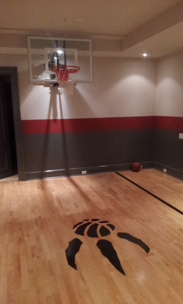 This is an example of a mid-sized modern indoor sport court in Toronto with multi-coloured walls and light hardwood floors.
