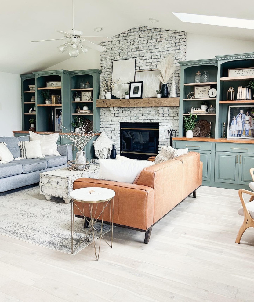 Design ideas for a mid-sized country enclosed living room in Los Angeles with green walls, light hardwood floors, a standard fireplace, a brick fireplace surround, white floor and vaulted.