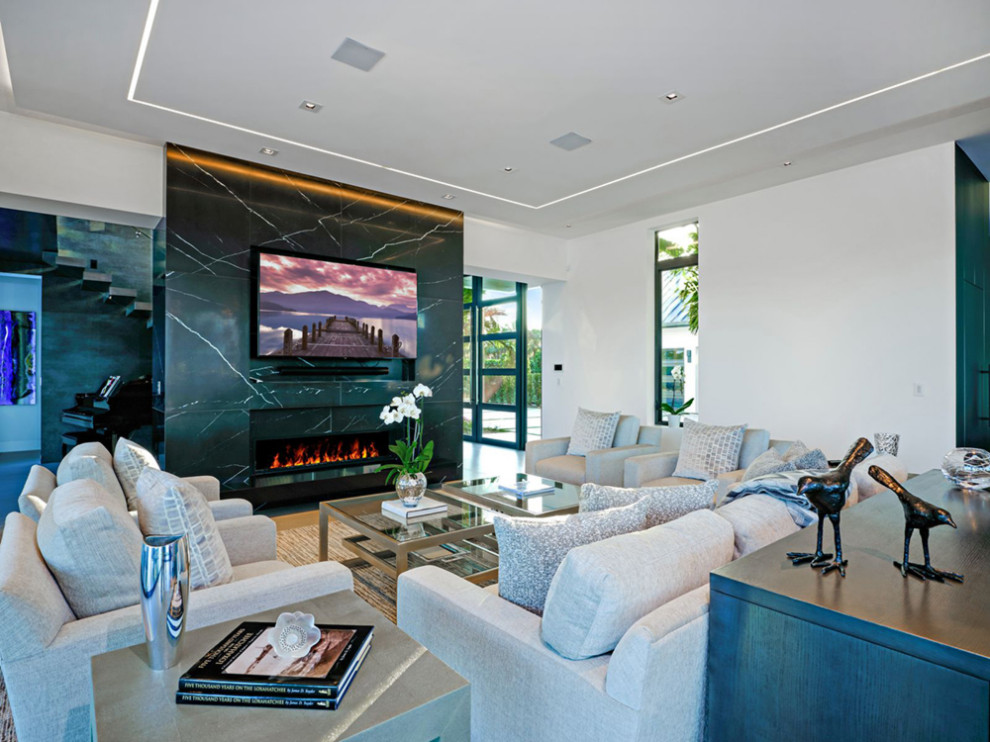 Cette image montre un salon design avec un mur blanc, une cheminée ribbon et un téléviseur fixé au mur.