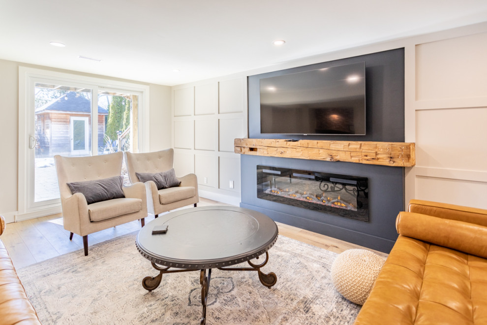 Mittelgroßes Landhaus Wohnzimmer mit weißer Wandfarbe, hellem Holzboden, Hängekamin, Kaminumrandung aus Holz, TV-Wand, blauem Boden und vertäfelten Wänden in Toronto