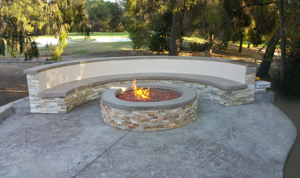 This is an example of a mid-sized modern backyard patio in Los Angeles with a fire feature, no cover and stamped concrete.