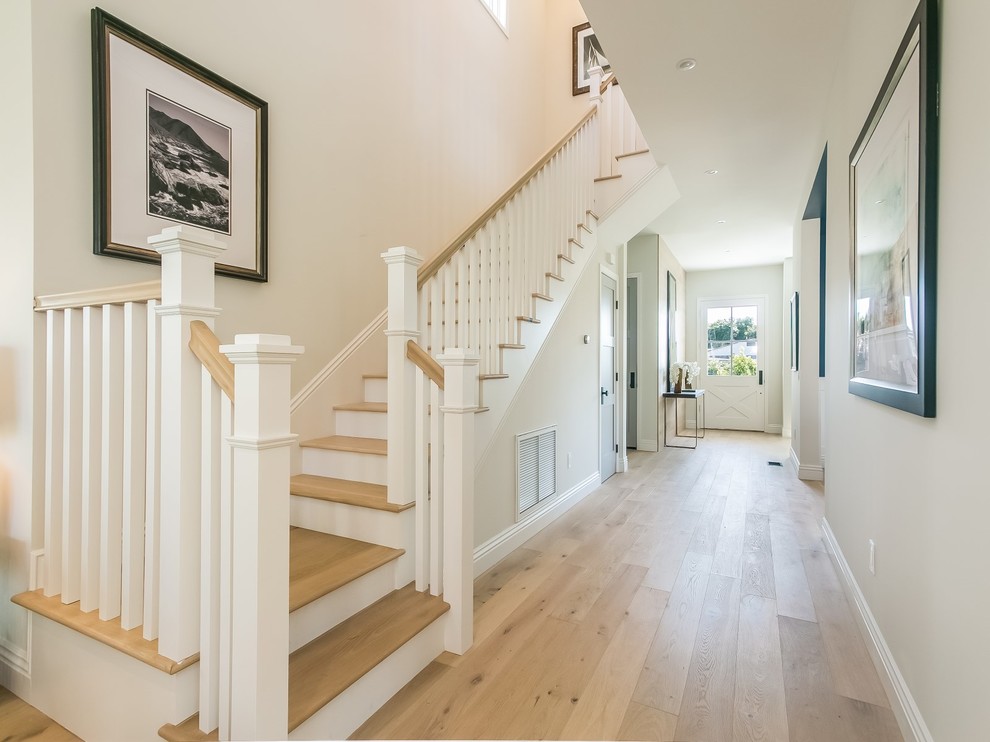 This is an example of a transitional wood l-shaped staircase in Los Angeles with wood railing.