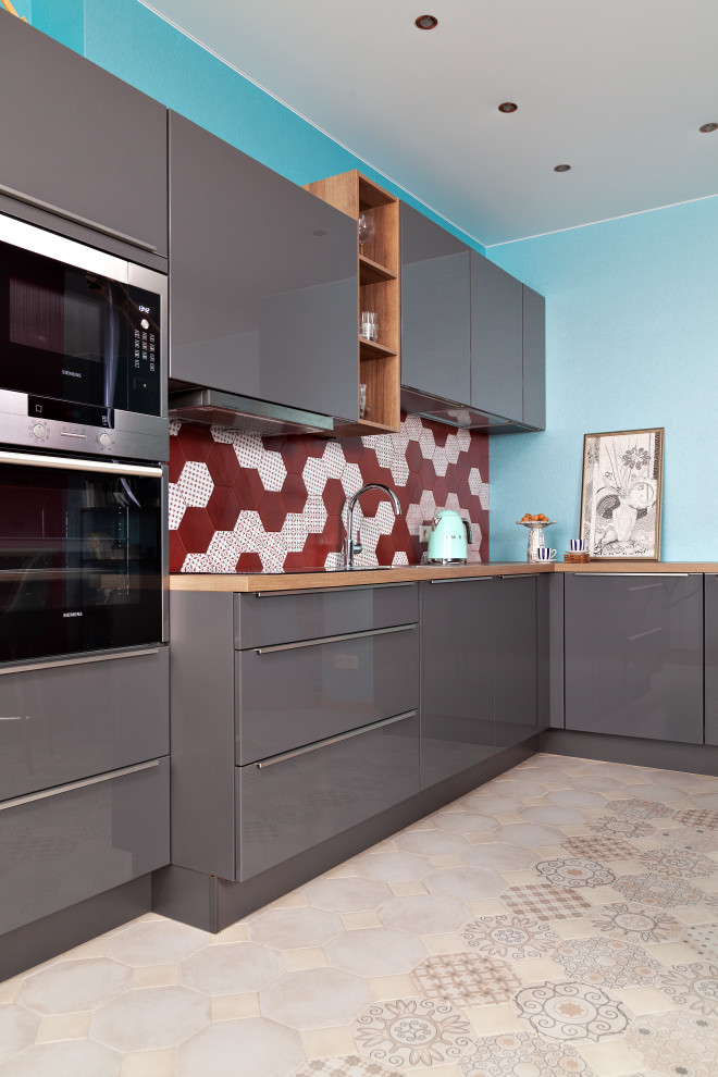 Photo of a mid-sized contemporary single-wall kitchen in Moscow with flat-panel cabinets, grey cabinets, red splashback, porcelain splashback, panelled appliances, porcelain floors, beige floor and beige benchtop.