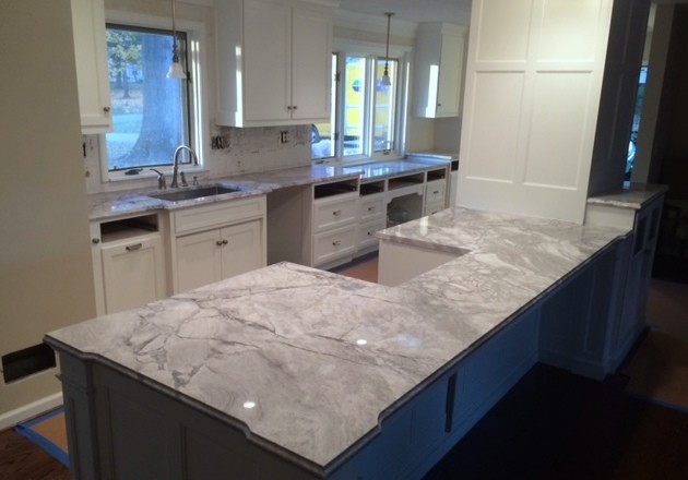 Example of a large minimalist galley eat-in kitchen design in Charleston with white cabinets, granite countertops and an island