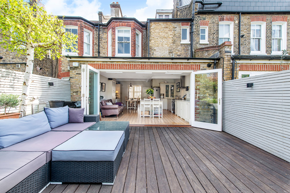 Design ideas for a large transitional backyard deck in London with no cover.