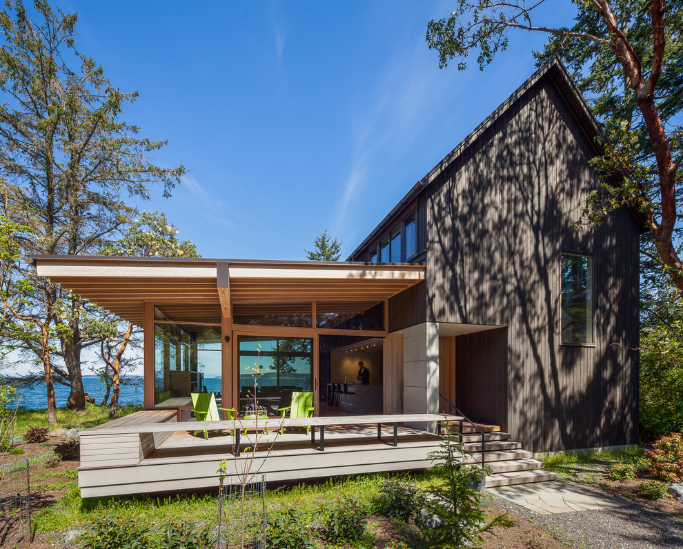 Inspiration for a beach style two-storey brown exterior in Seattle with wood siding and a gable roof.
