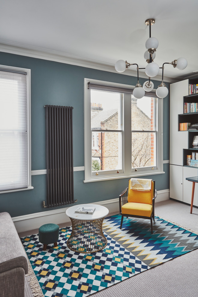 На фото: рабочее место среднего размера в стиле модернизм с синими стенами, ковровым покрытием, встроенным рабочим столом и разноцветным полом без камина