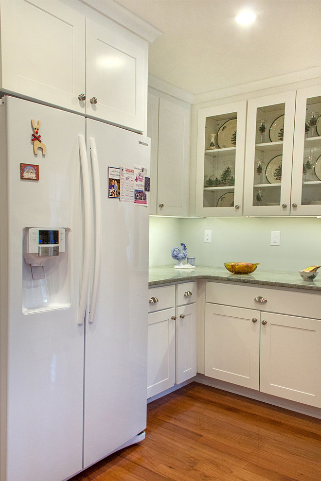 Transitional l-shaped eat-in kitchen photo with an undermount sink, shaker cabinets, white cabinets, granite countertops, green backsplash, glass tile backsplash and white appliances