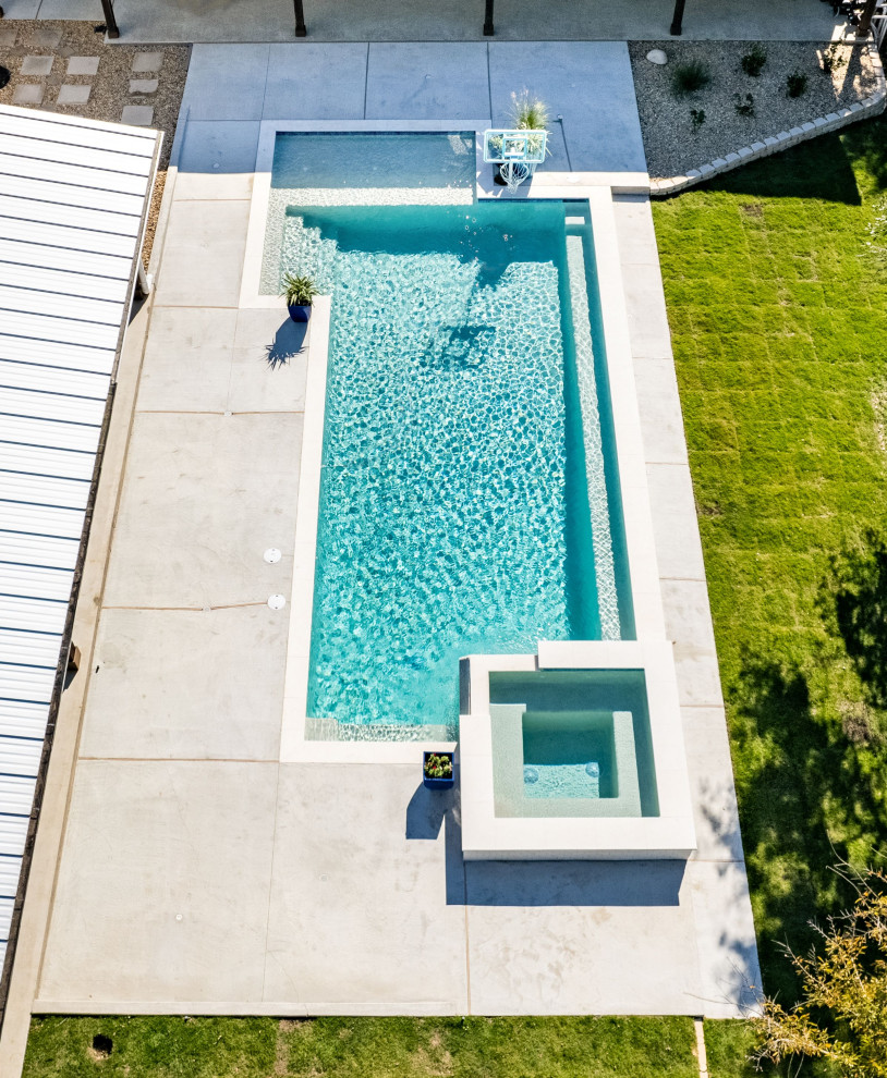 Idee per una piscina minimalista personalizzata di medie dimensioni e dietro casa con una vasca idromassaggio e pavimentazioni in pietra naturale