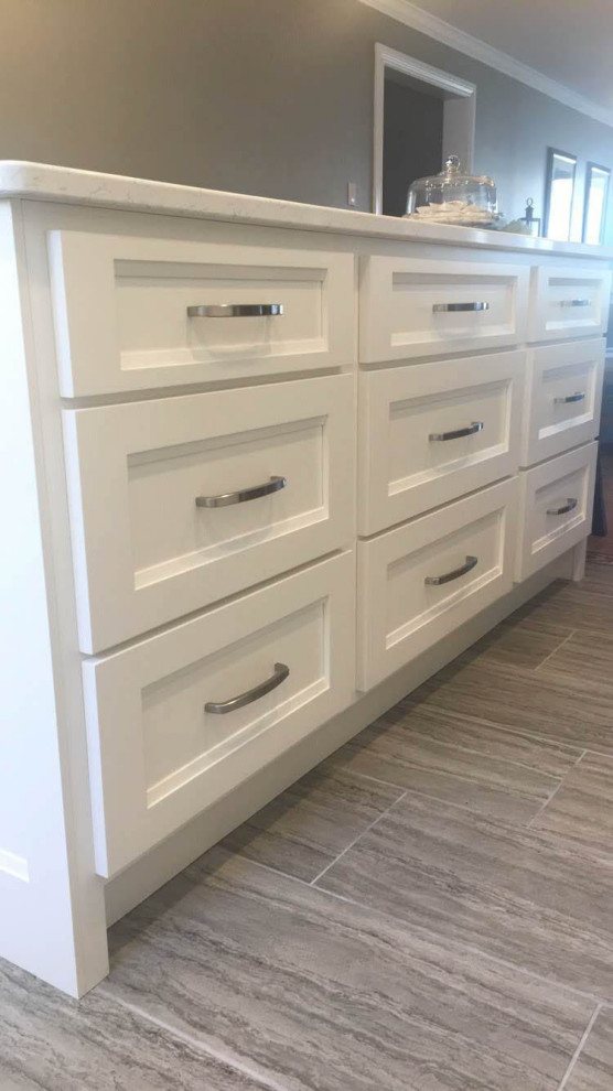 Mid-sized transitional u-shaped porcelain tile and gray floor eat-in kitchen photo with an undermount sink, recessed-panel cabinets, white cabinets, quartz countertops, stainless steel appliances, an island and white countertops