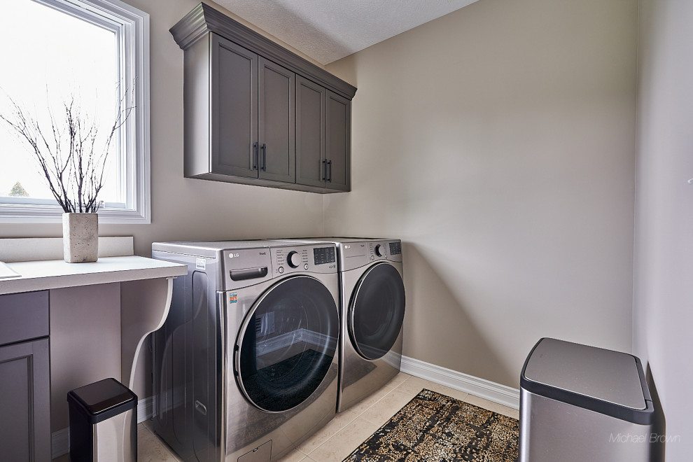 This is an example of a small transitional single-wall dedicated laundry room in Other with a drop-in sink, recessed-panel cabinets, grey cabinets, laminate benchtops, grey walls, ceramic floors, a side-by-side washer and dryer, yellow floor and yellow benchtop.