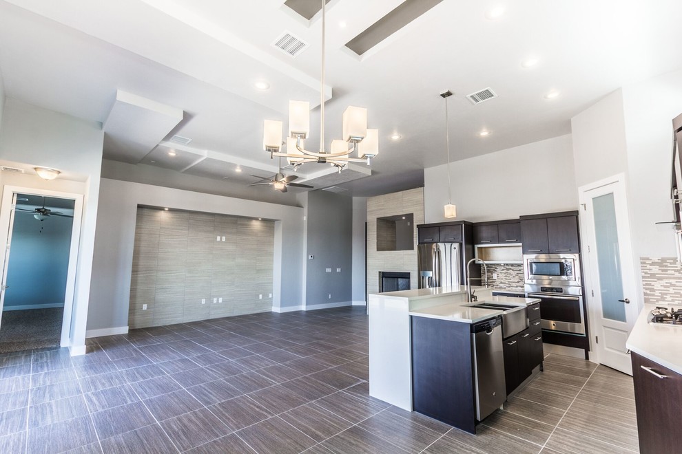 Example of a large transitional u-shaped ceramic tile home design design in Austin with a farmhouse sink, flat-panel cabinets, dark wood cabinets, quartzite countertops, gray backsplash, mosaic tile backsplash, stainless steel appliances and an island
