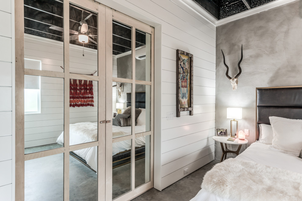 Esempio di una camera matrimoniale boho chic di medie dimensioni con pareti bianche, pavimento in cemento, pavimento grigio e soffitto in perlinato