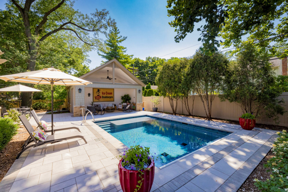 Pool house - small traditional backyard stone and rectangular pool house idea in Chicago