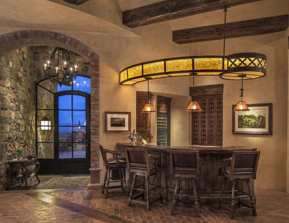 Photo of a mid-sized l-shaped seated home bar in Phoenix with medium wood cabinets, wood benchtops, brick floors and brown floor.