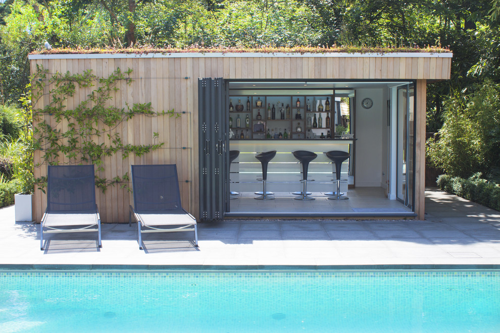 Contemporary swimming pool in Dorset with open cabinets and a bar area.